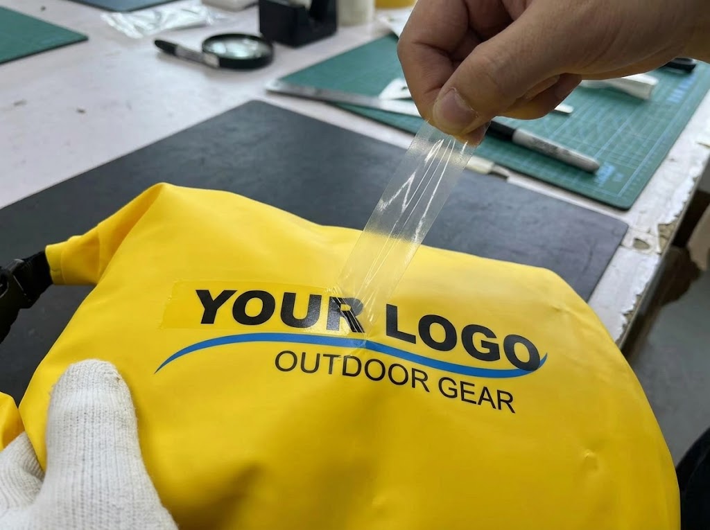 Tape adhesion test being pulled off a printed logo